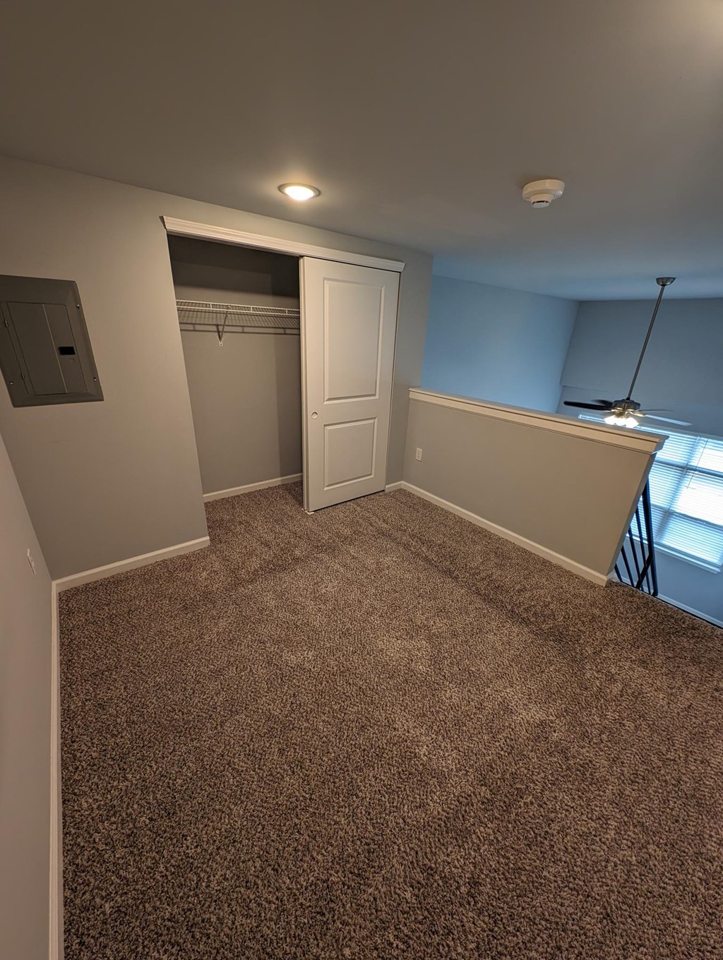 a room with a carpeted floor and a door to a closet