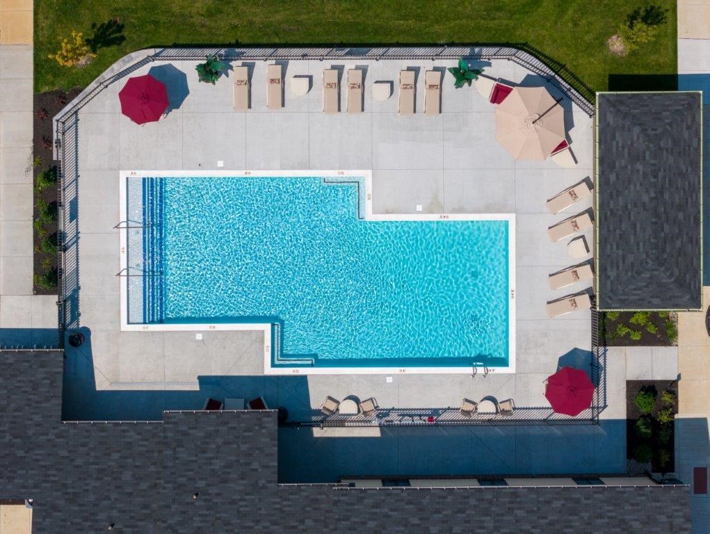 an aerial view of a swimming pool with umbrellas
