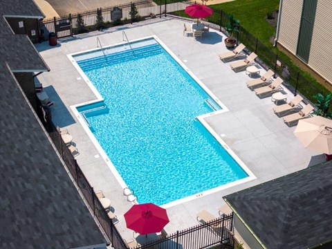 a swimming pool in a backyard with umbrellas and chairs