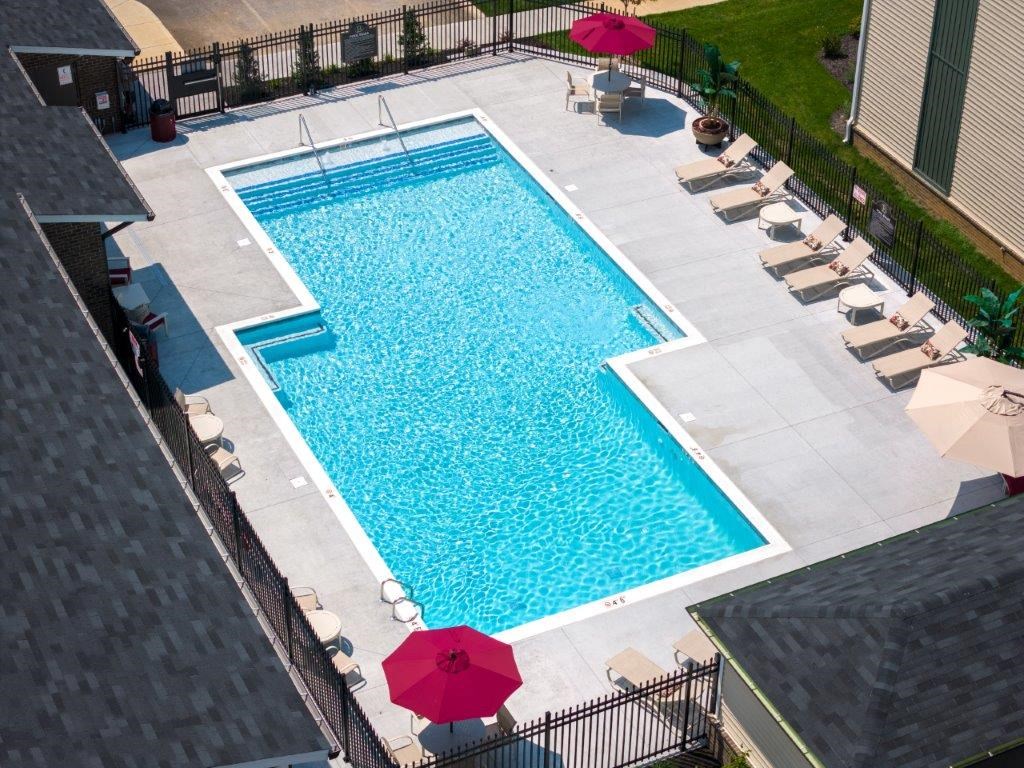 a swimming pool in a backyard with umbrellas and chairs