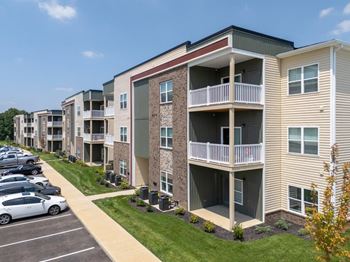 an exterior view of an apartment building with a parking lot