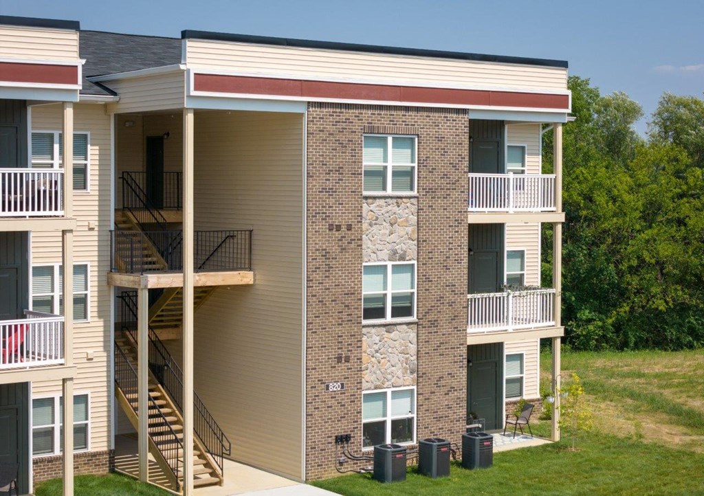 an exterior view of a building with stairs and balconies