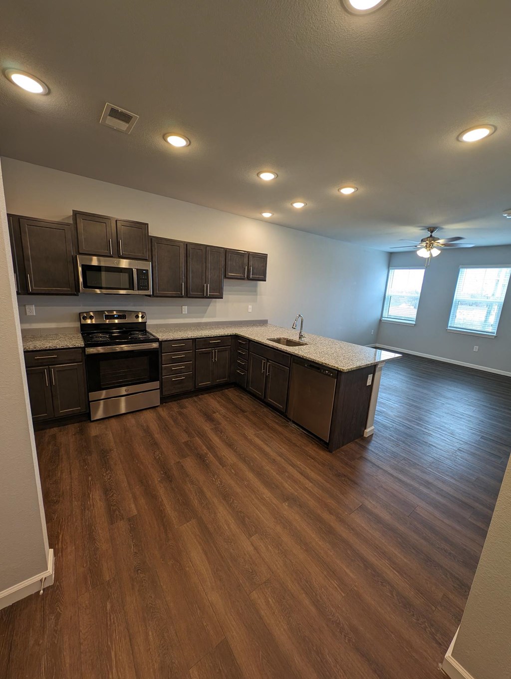 an empty kitchen with wooden floors and wooden cabinets