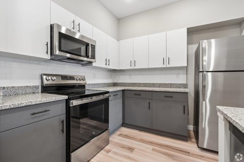 A kitchen with a stainless steel refrigerator and microwave.