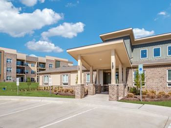 A modern building with a parking lot in front.