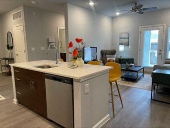a kitchen with an island in the middle of a living room