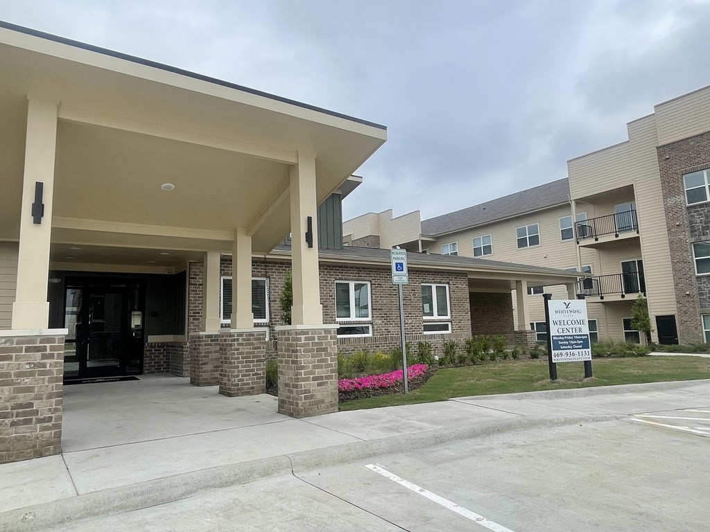 a building with a parking lot and a sign in front of it