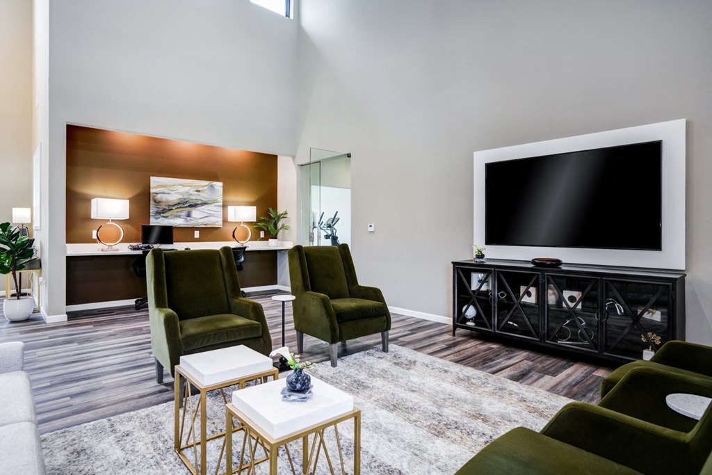 A living room with a large flat screen TV and a coffee table.
