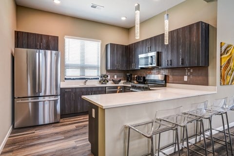 A kitchen with a white counter top and a refrigerator.