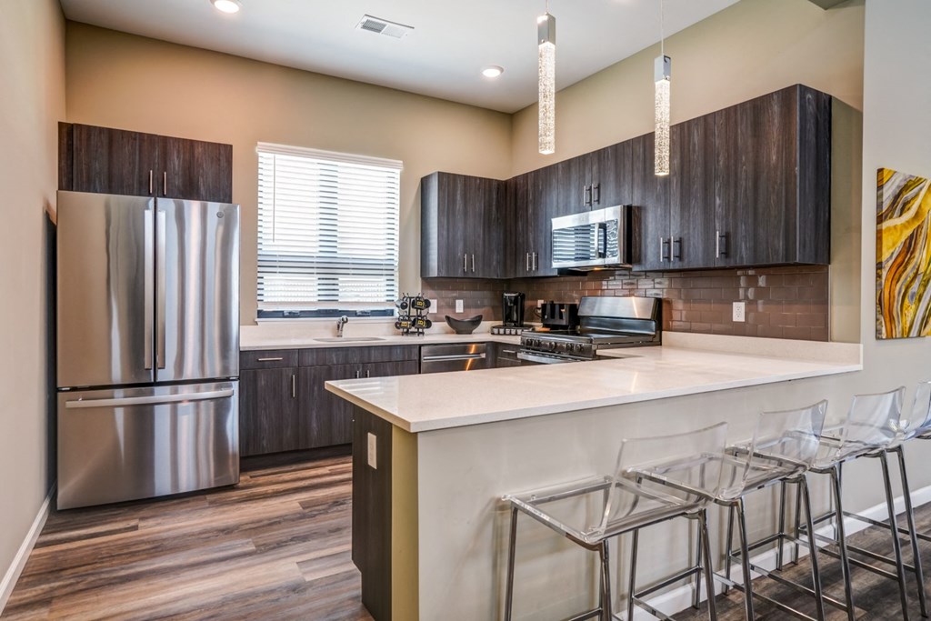 A kitchen with a white counter top and a refrigerator.