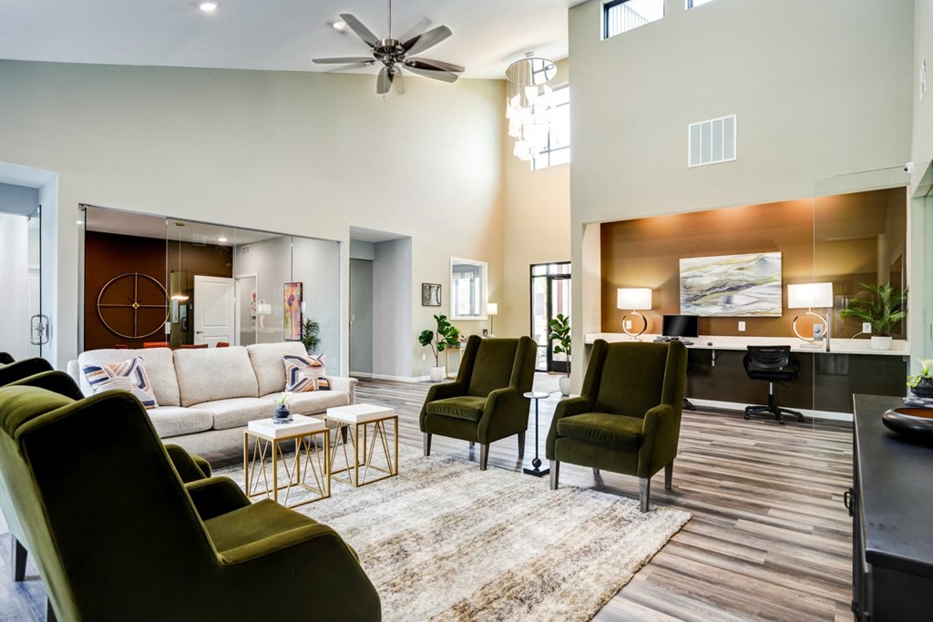 A living room with a white couch, a green chair, and a wooden floor.