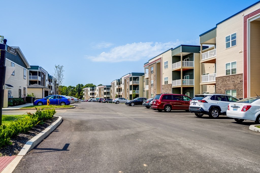 A parking lot with cars and apartment buildings in the background.