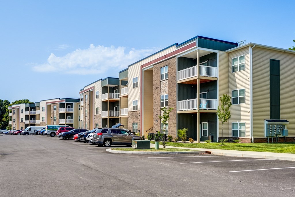 A parking lot in front of apartment buildings.