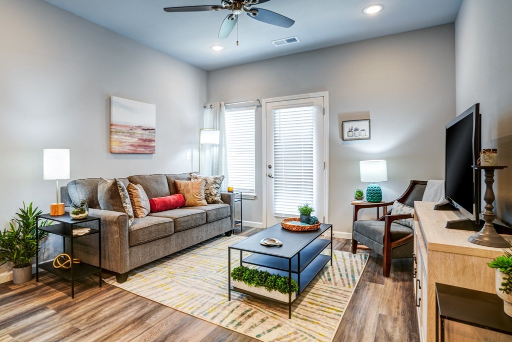 A living room with a couch, a coffee table, and a television.