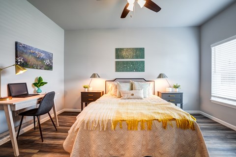 A bedroom with a bed, desk, and chair.