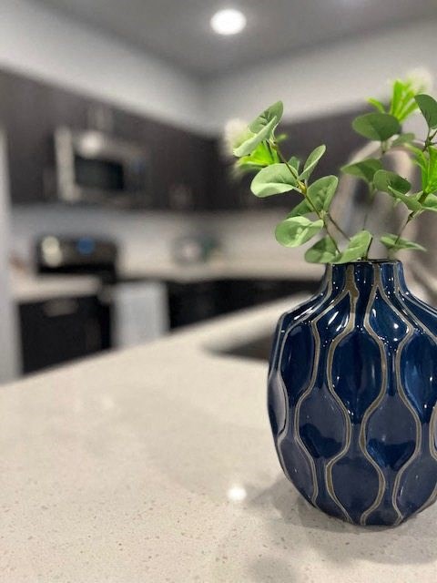 a blue vase with a plant on a table