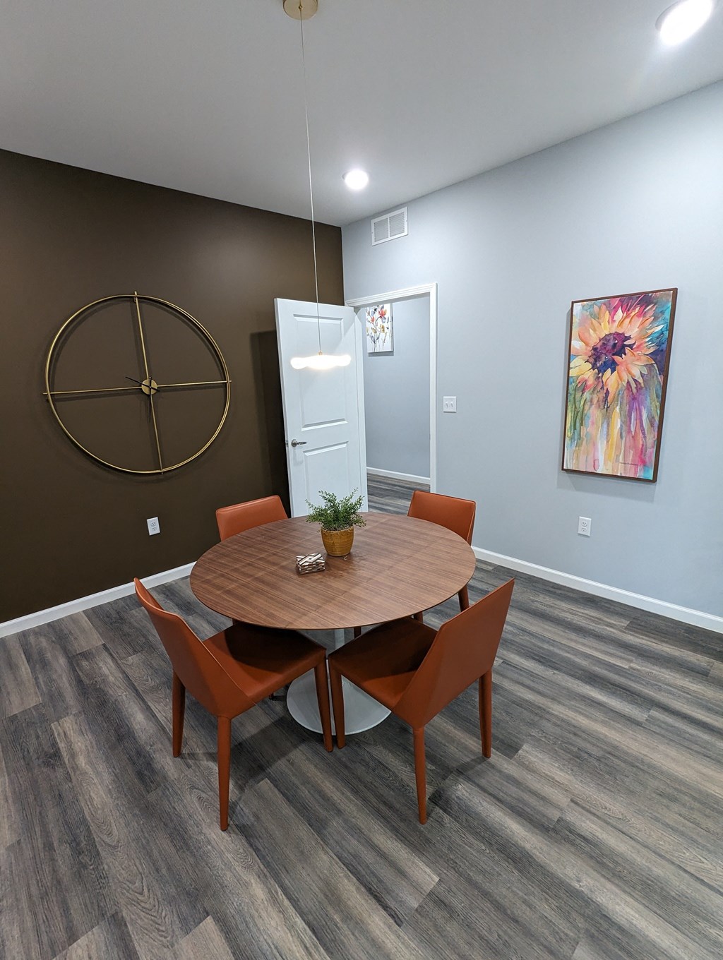 a dining room with a wooden table and orange chairs