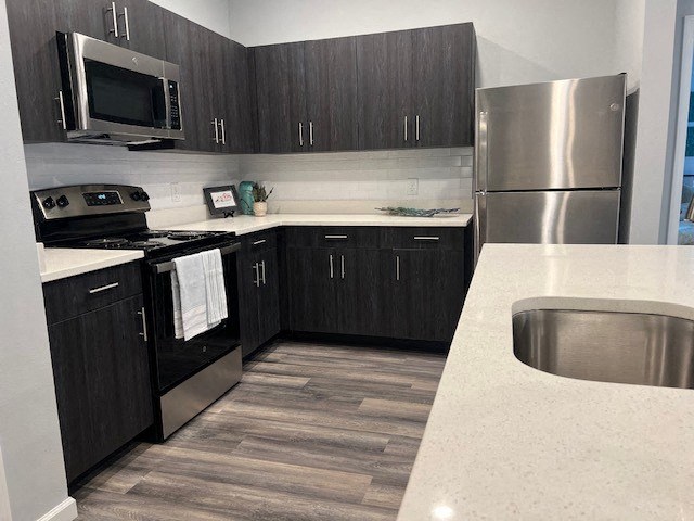a kitchen with stainless steel appliances and black cabinets