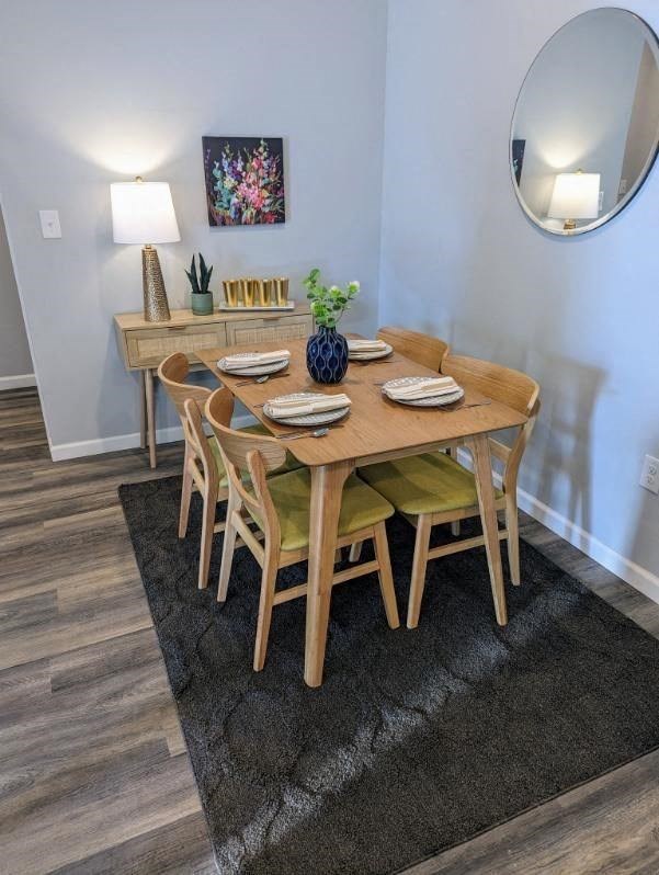 a dining room table with chairs and a mirror