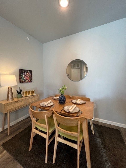 a table and chairs in a room with a mirror