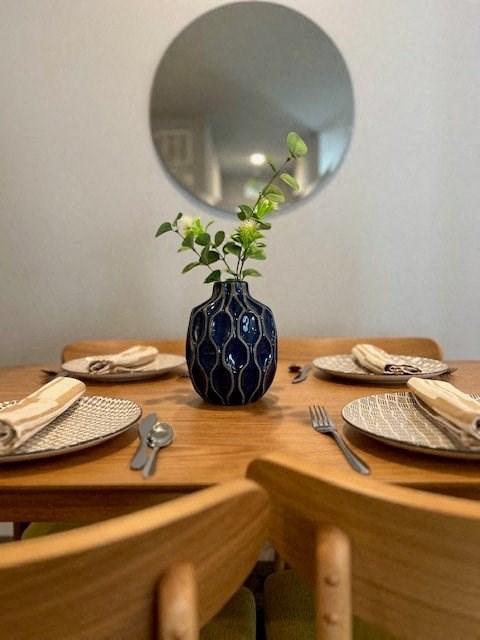 a table with plates and a vase with a plant on it