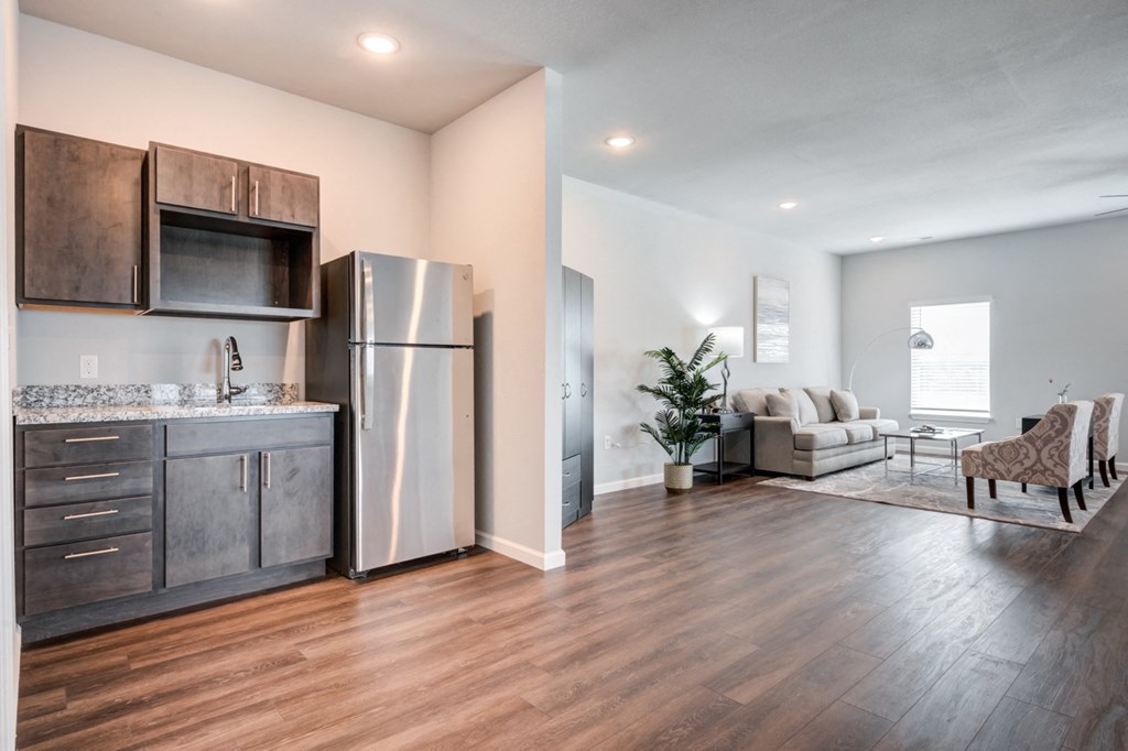 a kitchen and living room with a stainless steel refrigerator