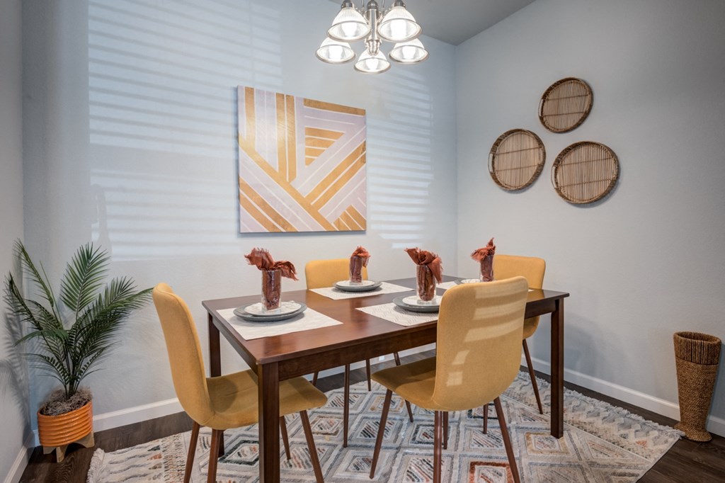 a dining room with a wooden table and chairs and a painting