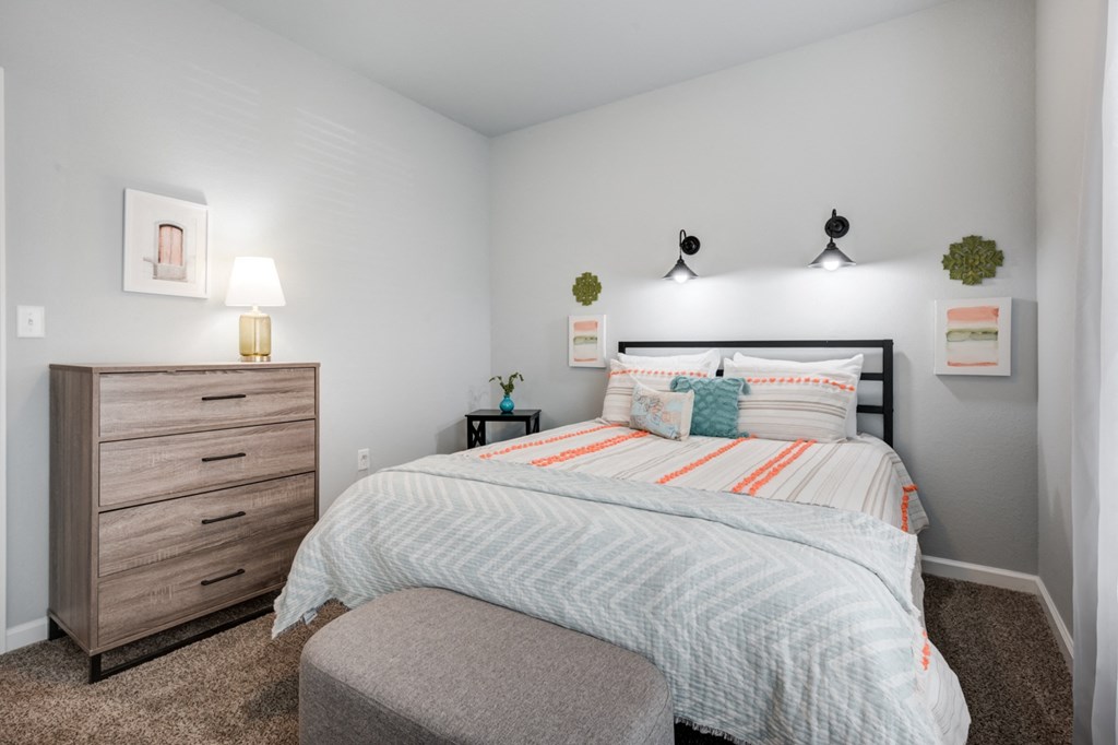 a bedroom with a bed and dresser and a chair