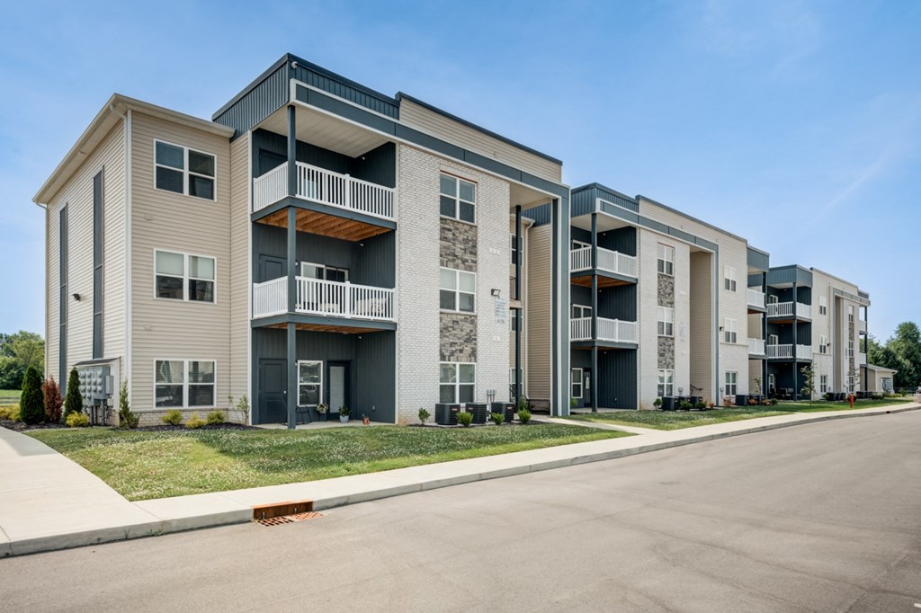 a row of apartment buildings with a street in front of them