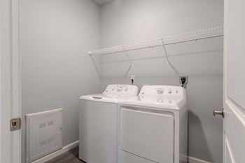 A white laundry room with a washer and dryer.