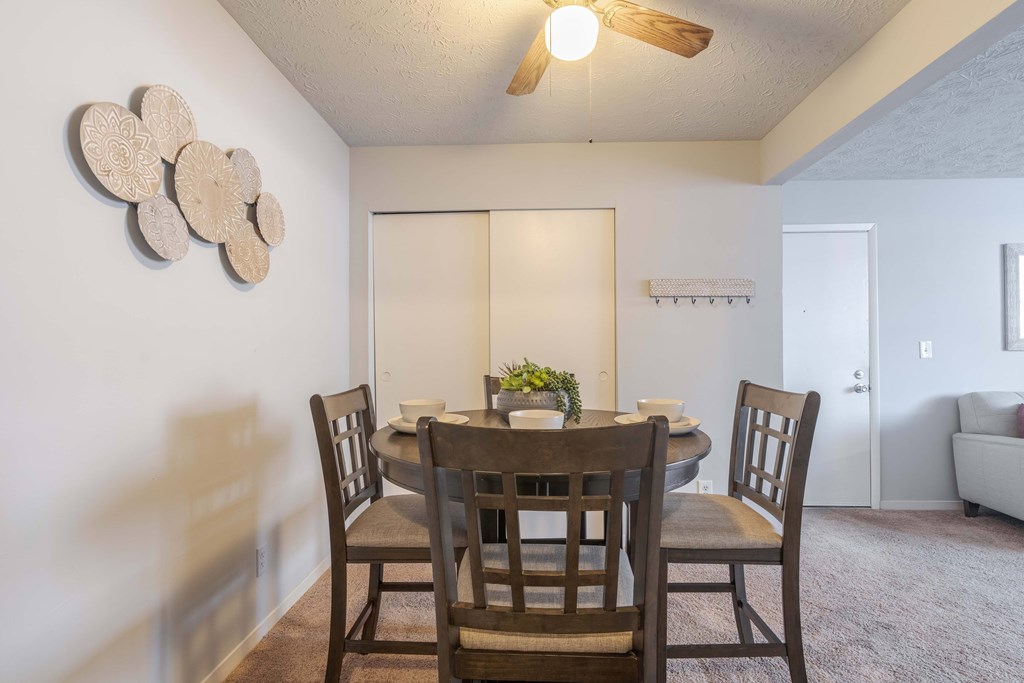 A dining room with a table and chairs.