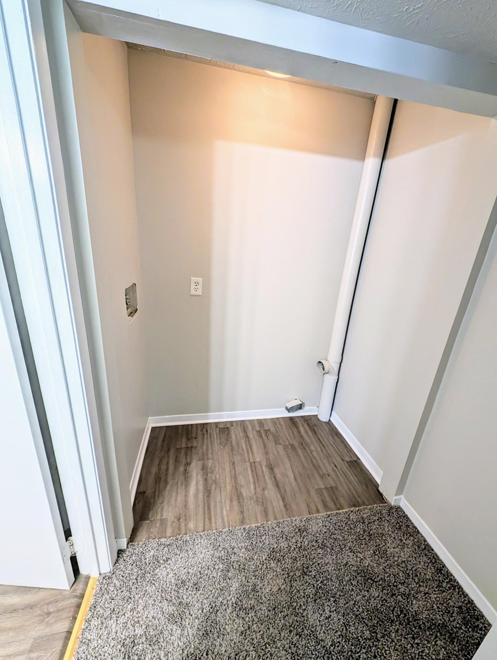 a room with a wood floor and white walls and a doorway