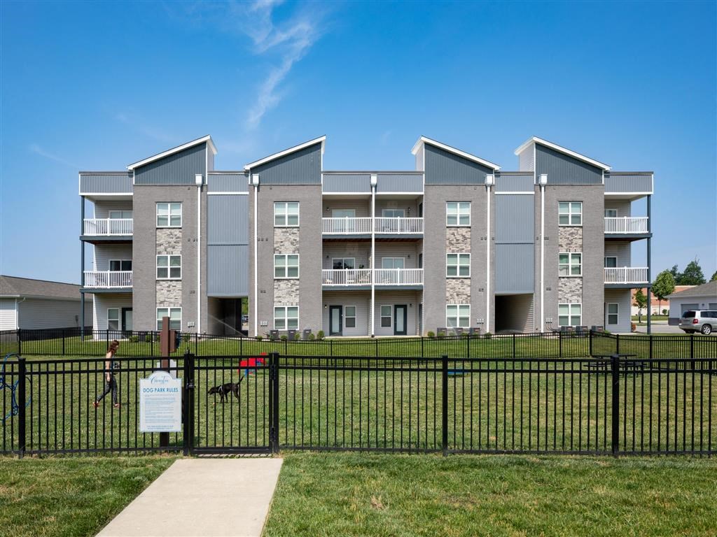 an apartment building with a black fence in front of it