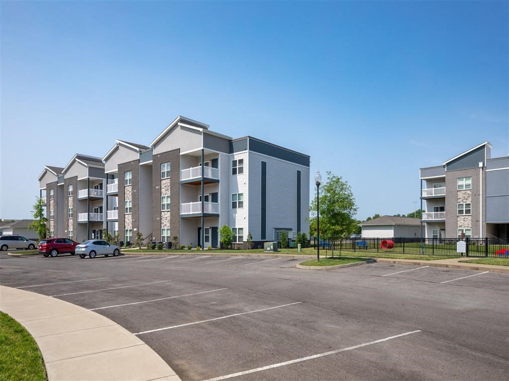 an empty parking lot in front of an apartment building