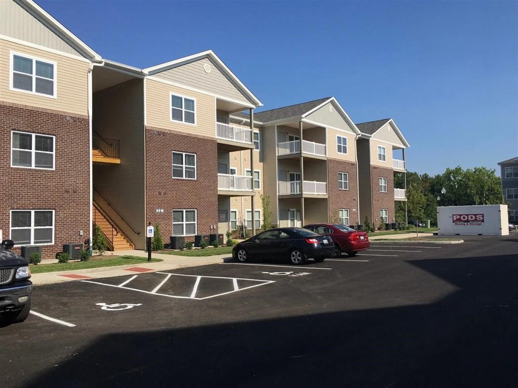 an empty parking lot in front of an apartment building