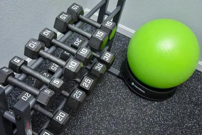 a pile of weights next to a green ball