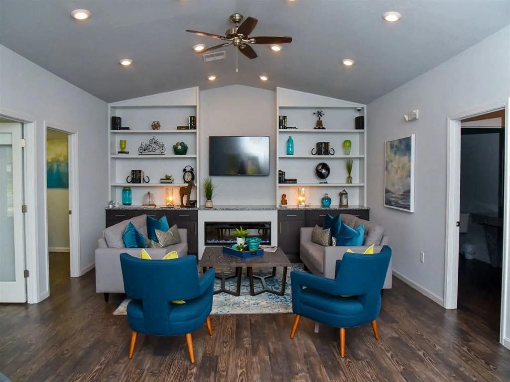 a living room with a couch and chairs and a tv