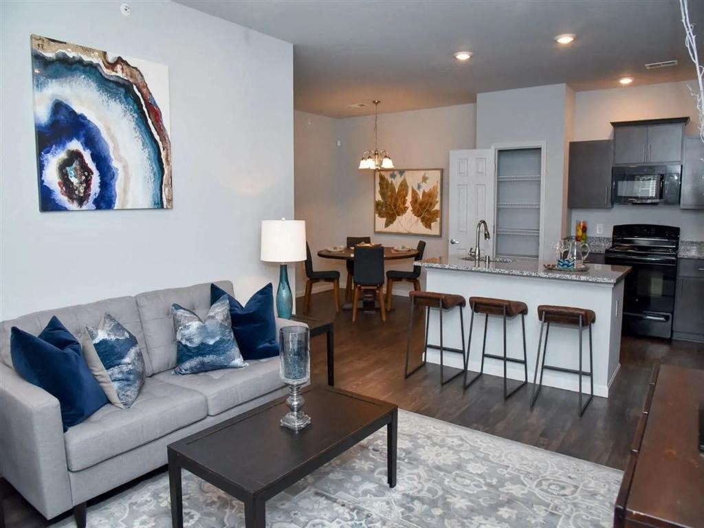 a living room and kitchen with a couch and a table