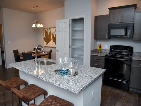 a kitchen with black appliances and a granite counter top