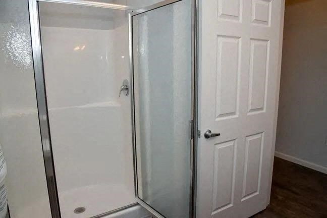 a bathroom with a shower and a white door