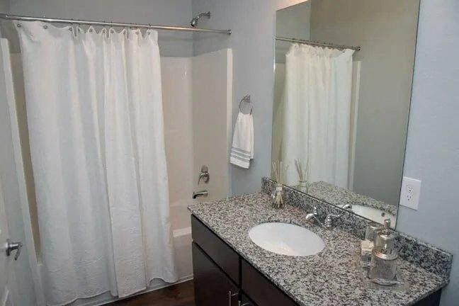 a bathroom with a white shower curtain and a sink