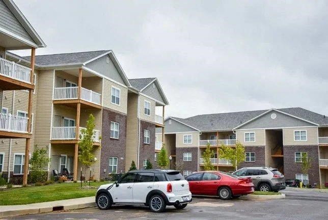 a row of cars parked in front of an apartment building