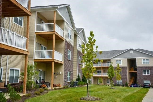 a row of apartment buildings with balconies and trees