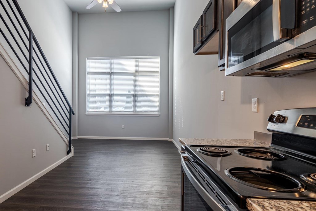 A kitchen with a stove top oven and microwave above it.
