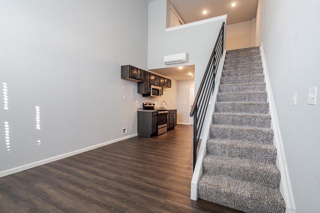 A staircase with a carpeted runner leads up to a second floor landing.