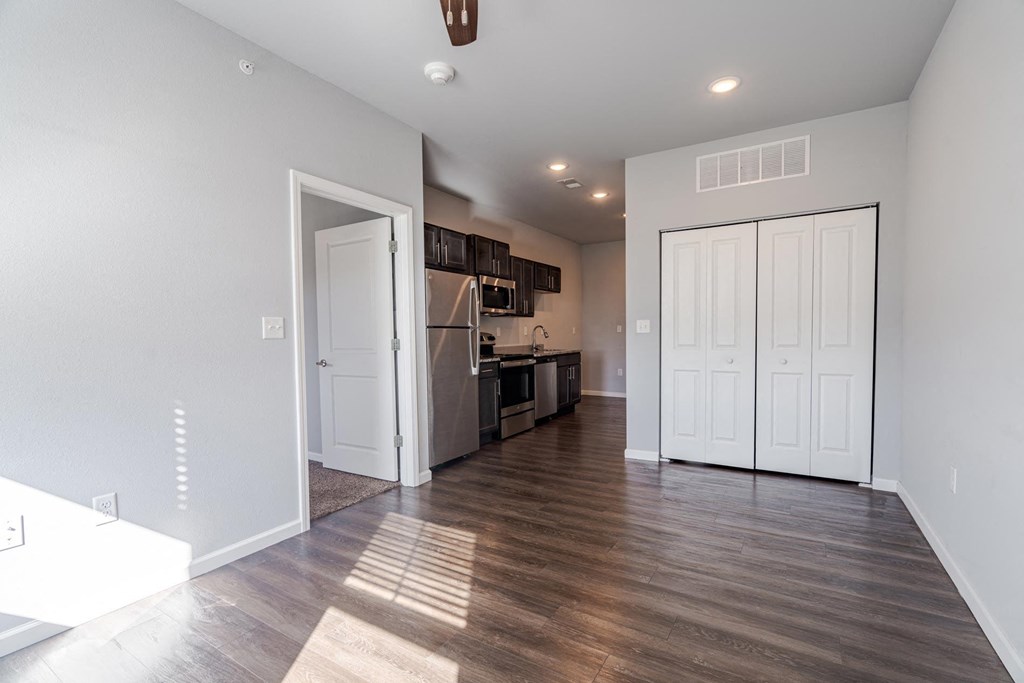 A kitchen with white cabinets and a wooden floor.
