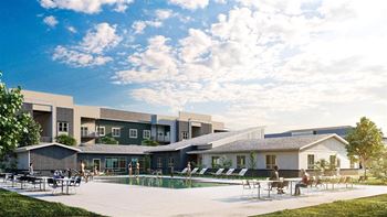 a group of people sitting around a pool in front of a building
