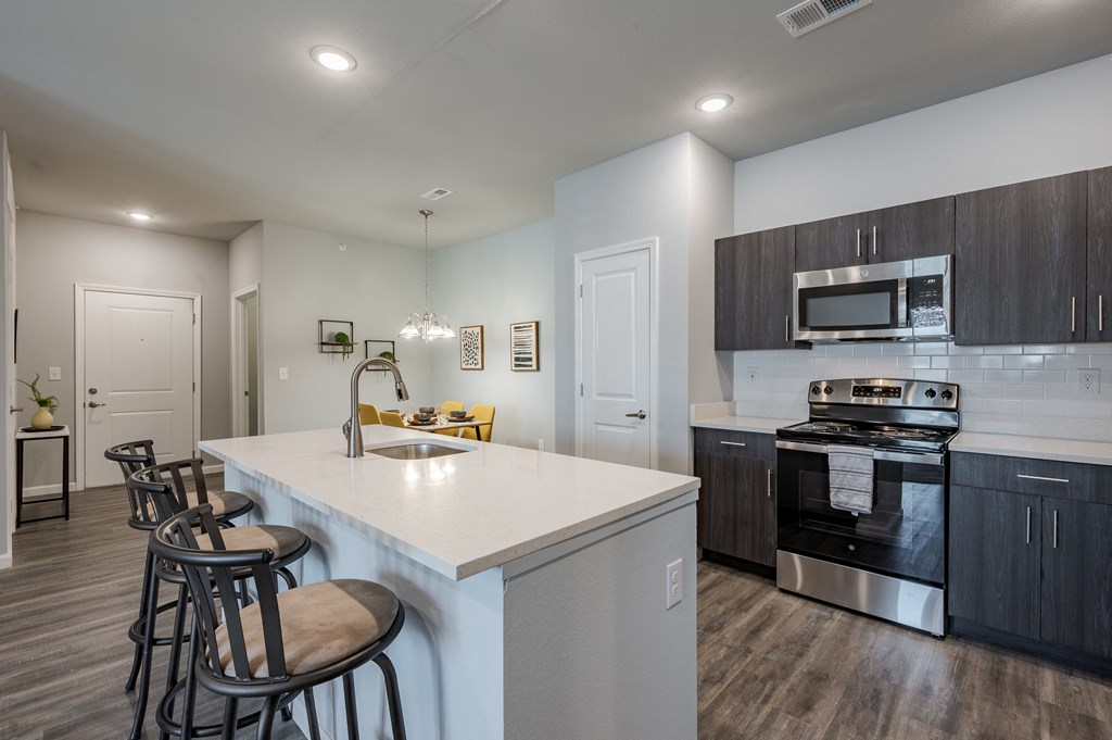 an open kitchen with a large island with stools