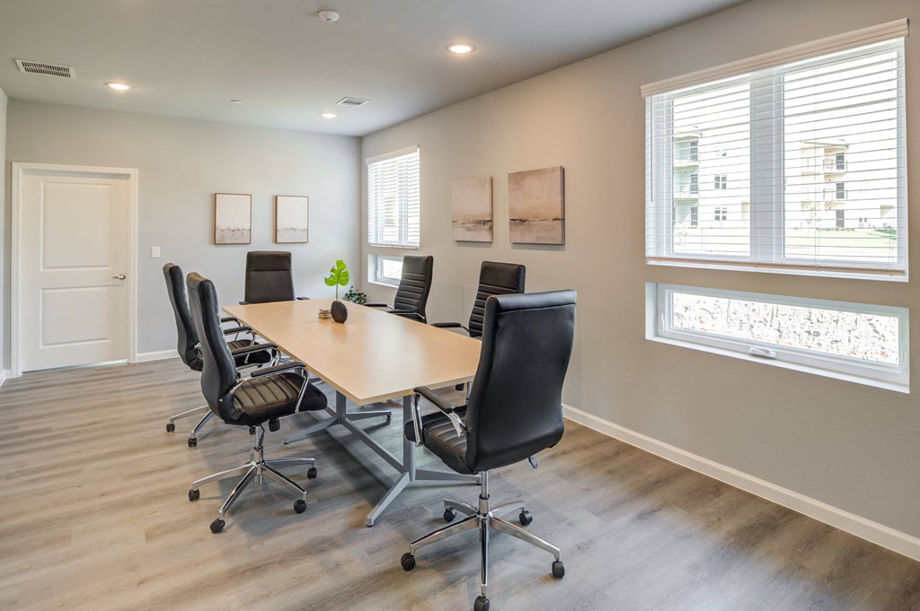 a conference room with a table and chairs and a window