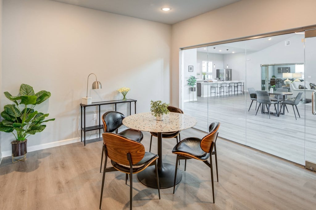 a dining area with a round table and chairs in front of a sliding glass door